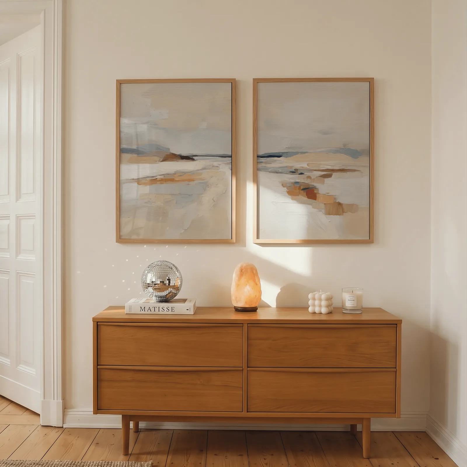 beige coastal abstract wall art set of two, above a wooden dresser with a salt lamp and disco ball