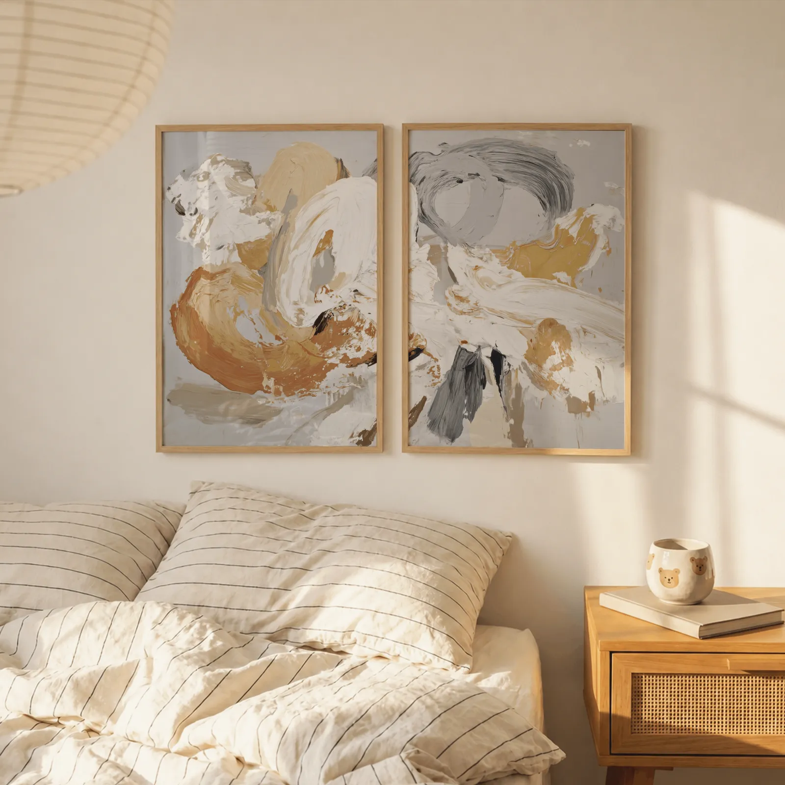 orange and grey abstract wall art set of two, above a striped linen bed beside a paper lantern shade