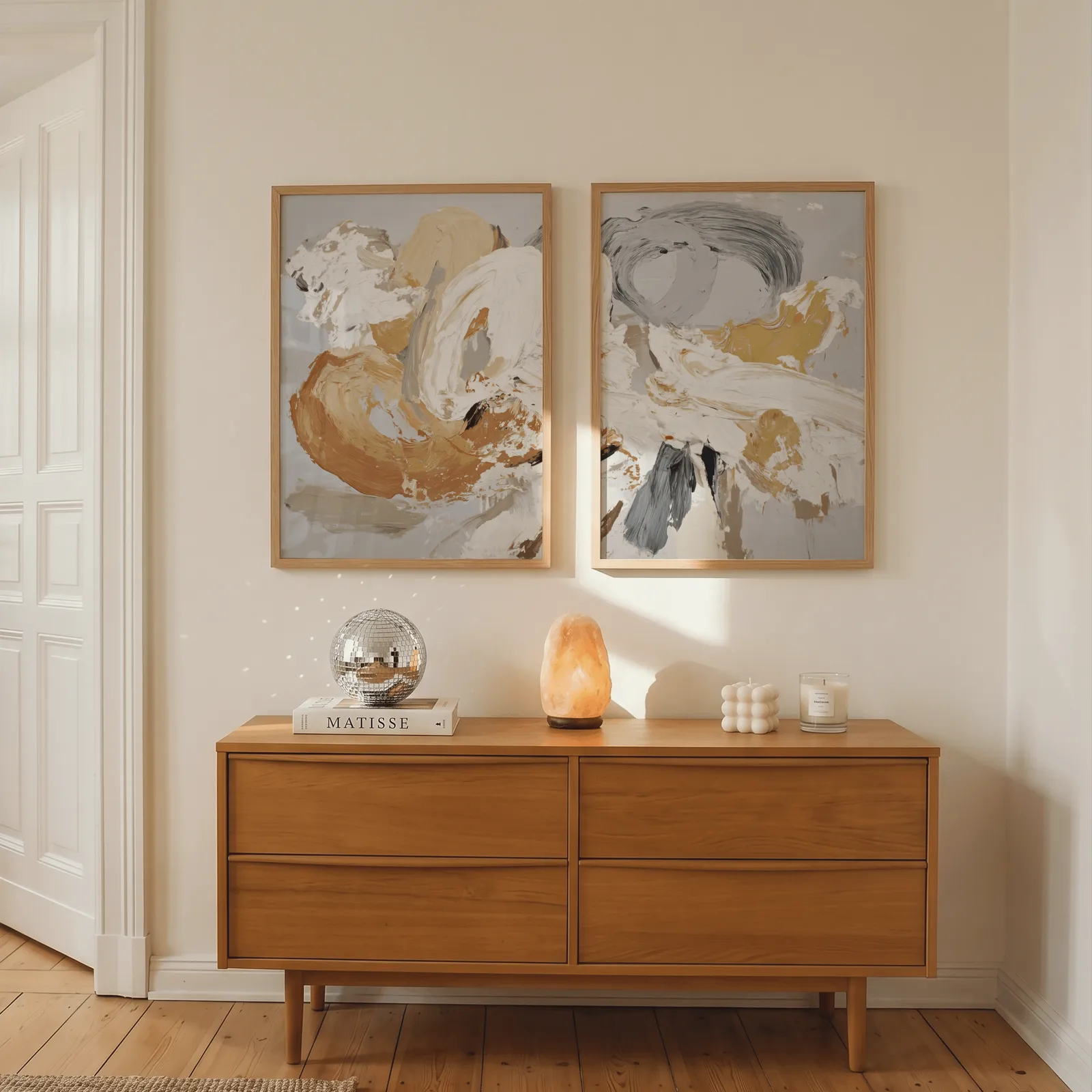 orange and grey abstract wall art set of two, above a wooden dresser with a salt lamp and disco ball