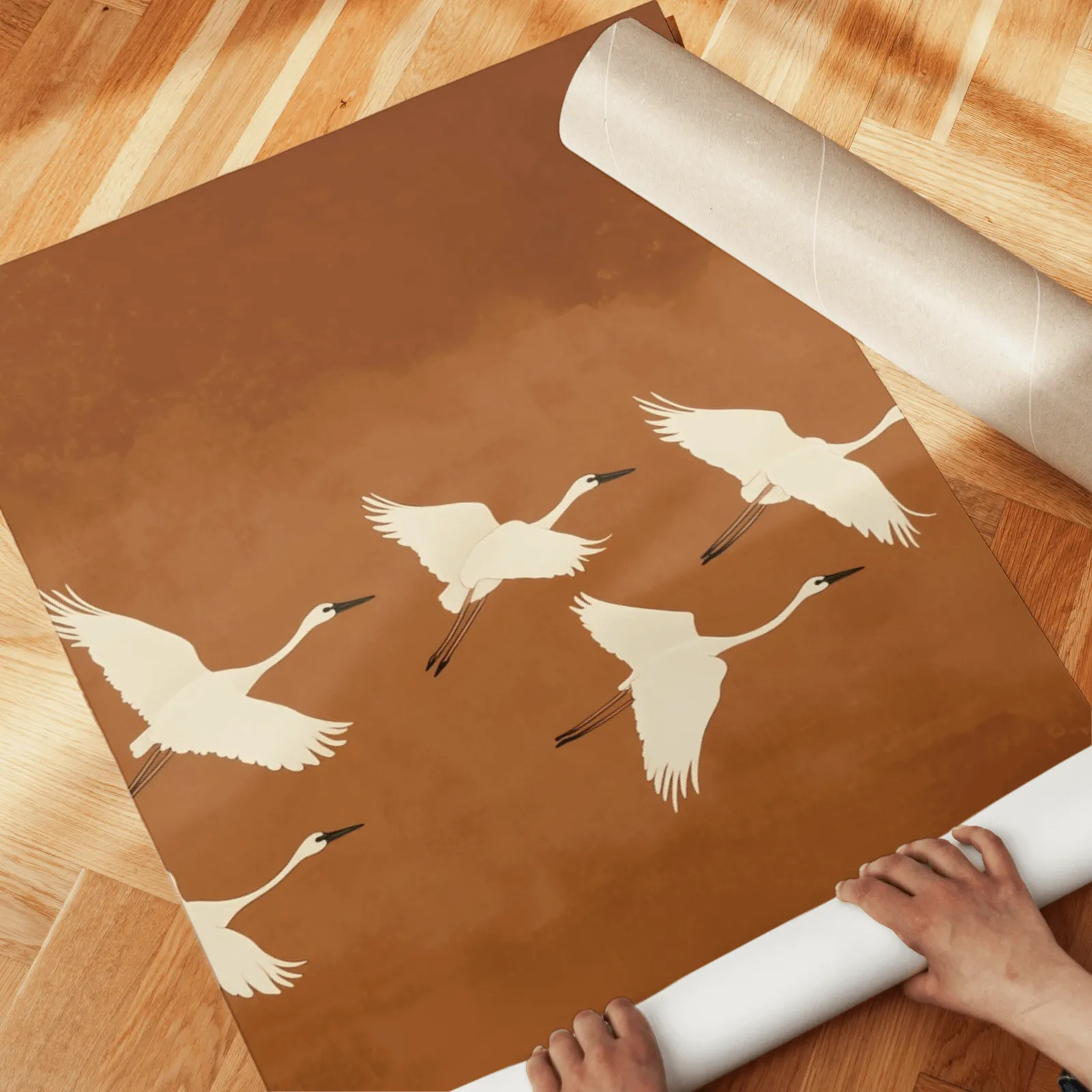 terracotta crane triptych wall art, unrolled across a herringbone wood floor by hand