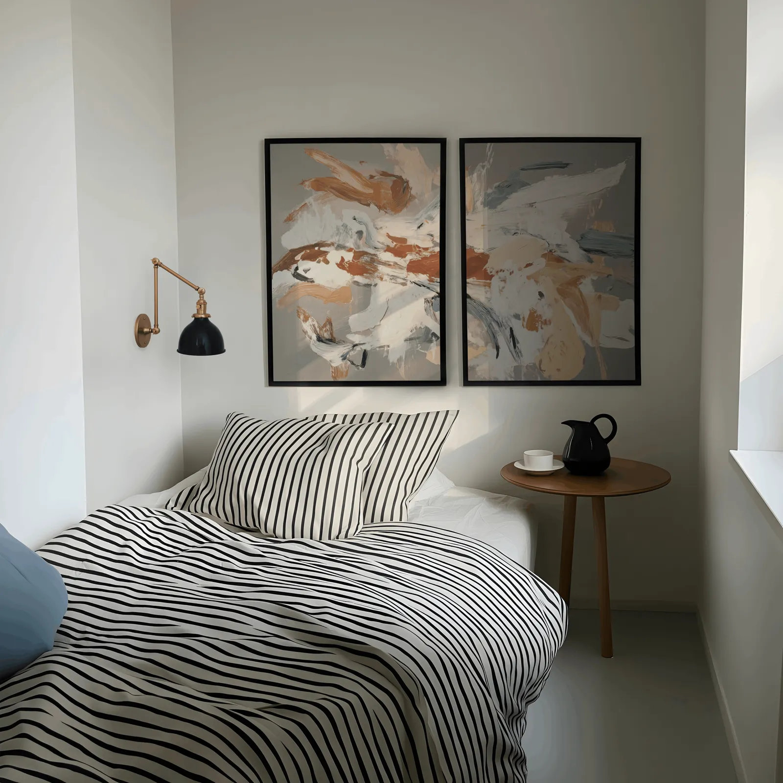 terracotta abstract wall art set of two, above a striped bed beside a brass swing-arm lamp