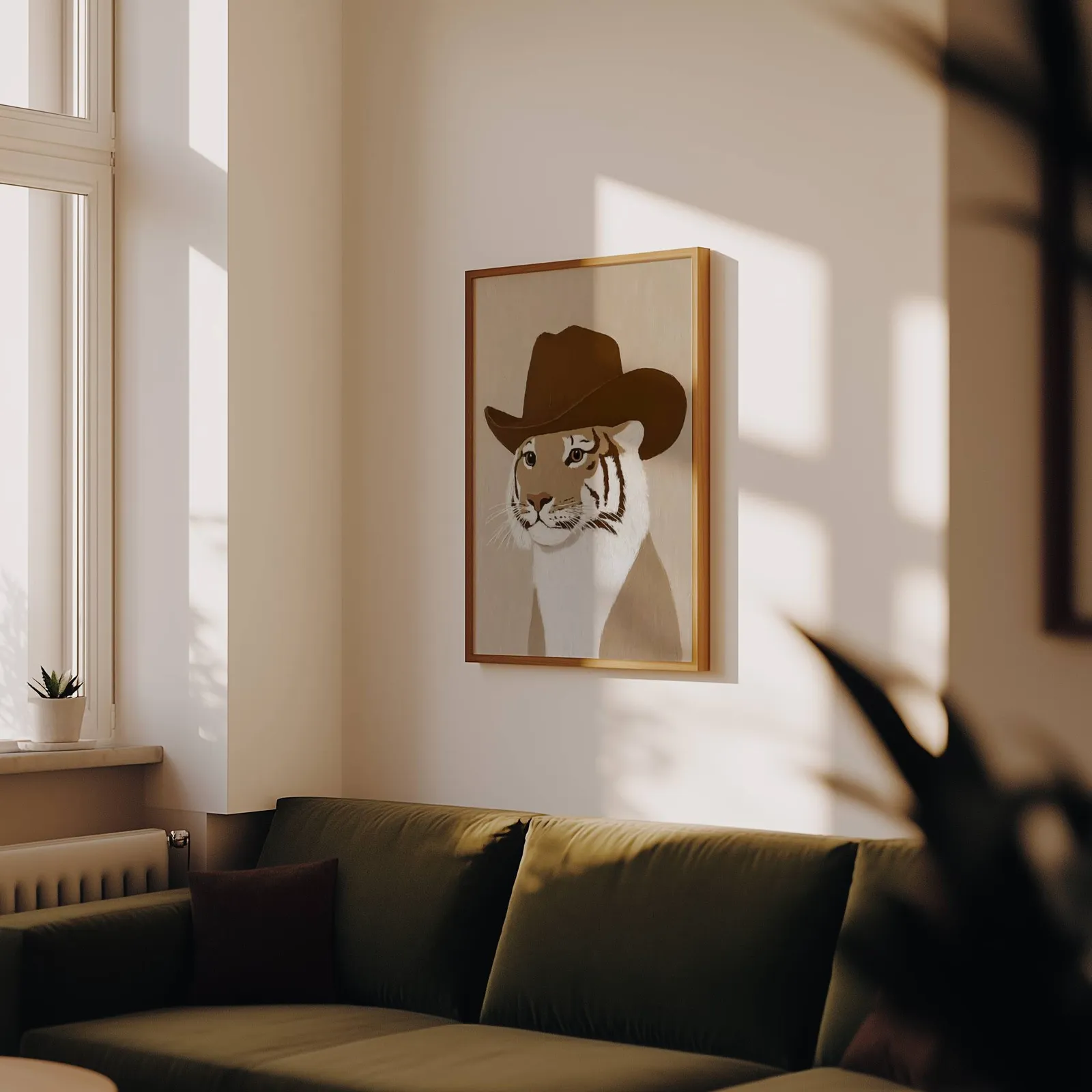 tiger in cowboy hat western wall art, above an olive velvet sofa in raking afternoon light