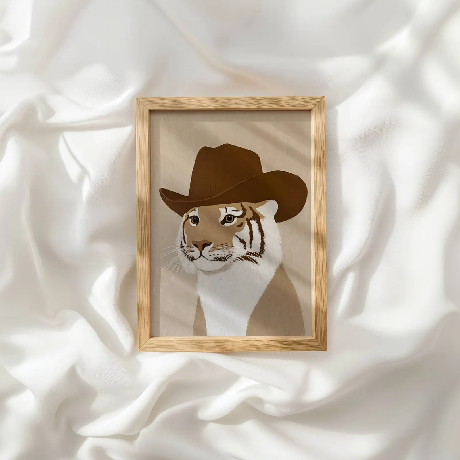 tiger in cowboy hat western wall art, resting atop rumpled white silky fabric
