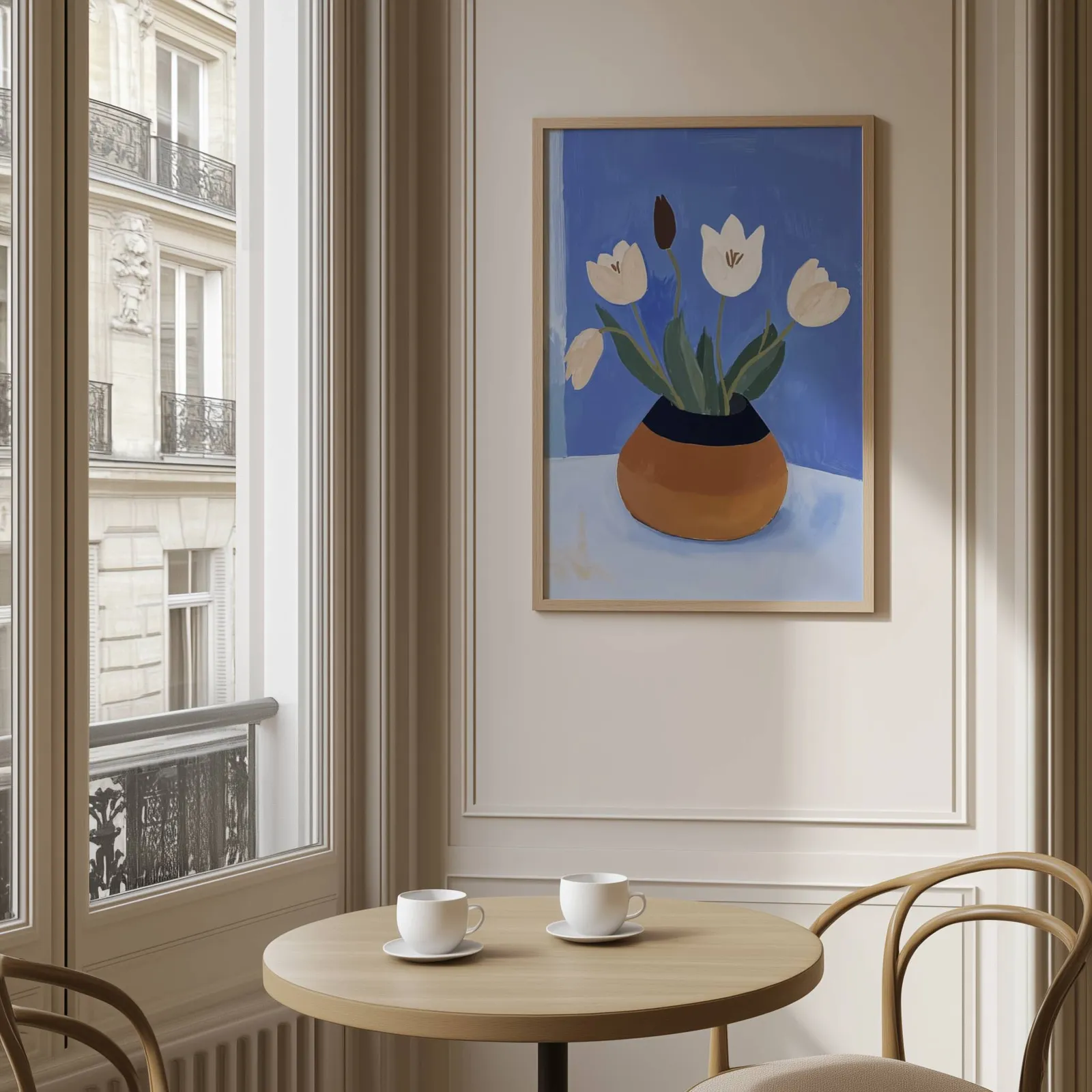white tulips in terracotta vase botanical wall art, above a round café table set with two coffee cups