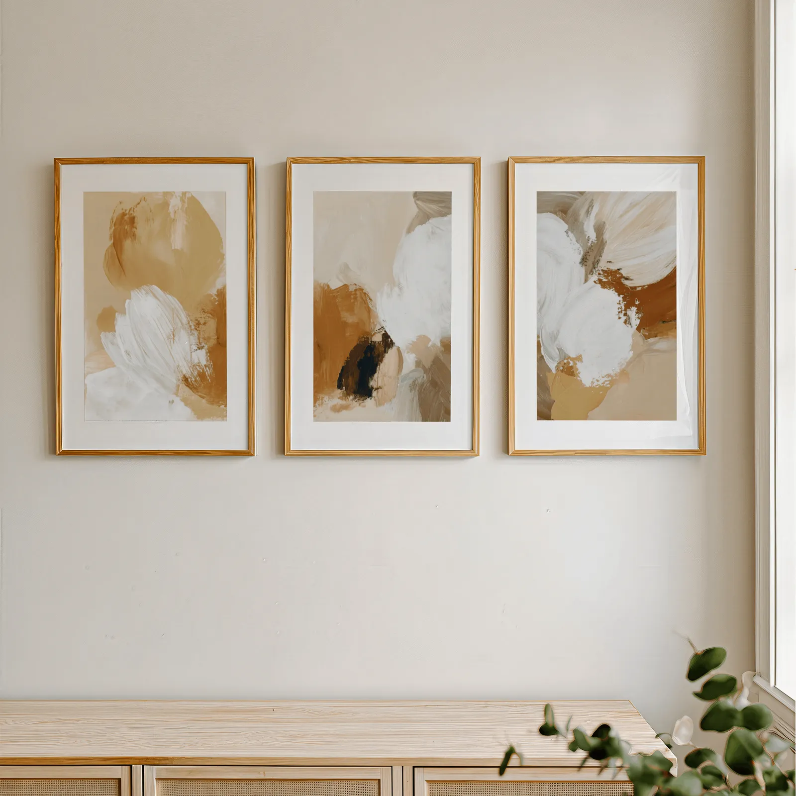 beige abstract triptych wall art set of 3, in a row above a light wooden sideboard near a window