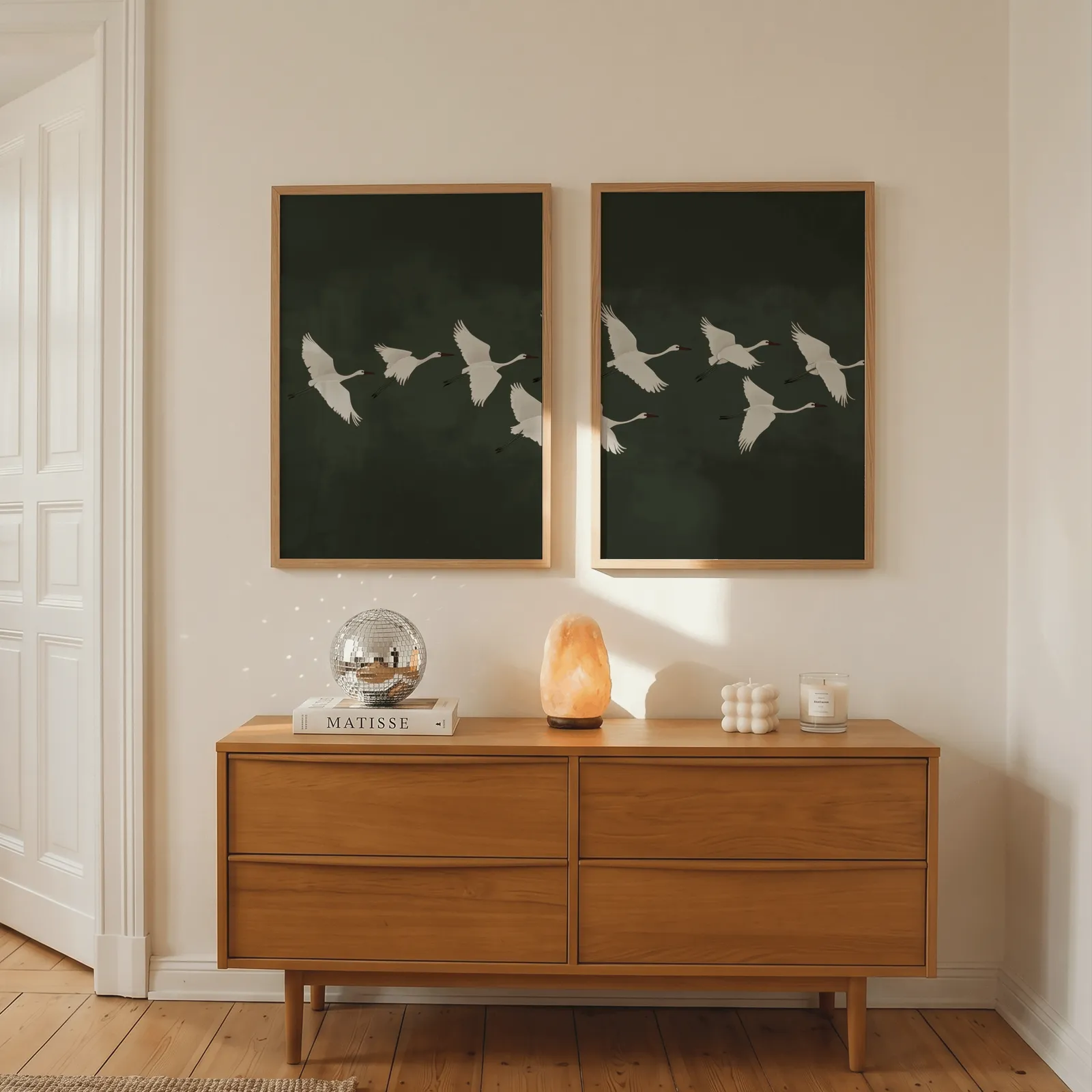green crane wall art set of two, above a wooden dresser with a salt lamp and disco ball
