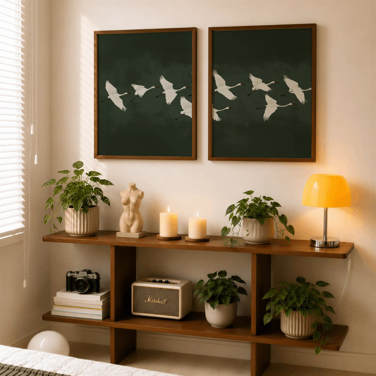 green crane wall art set of two, above a wooden console shelf with potted plants and a yellow lamp