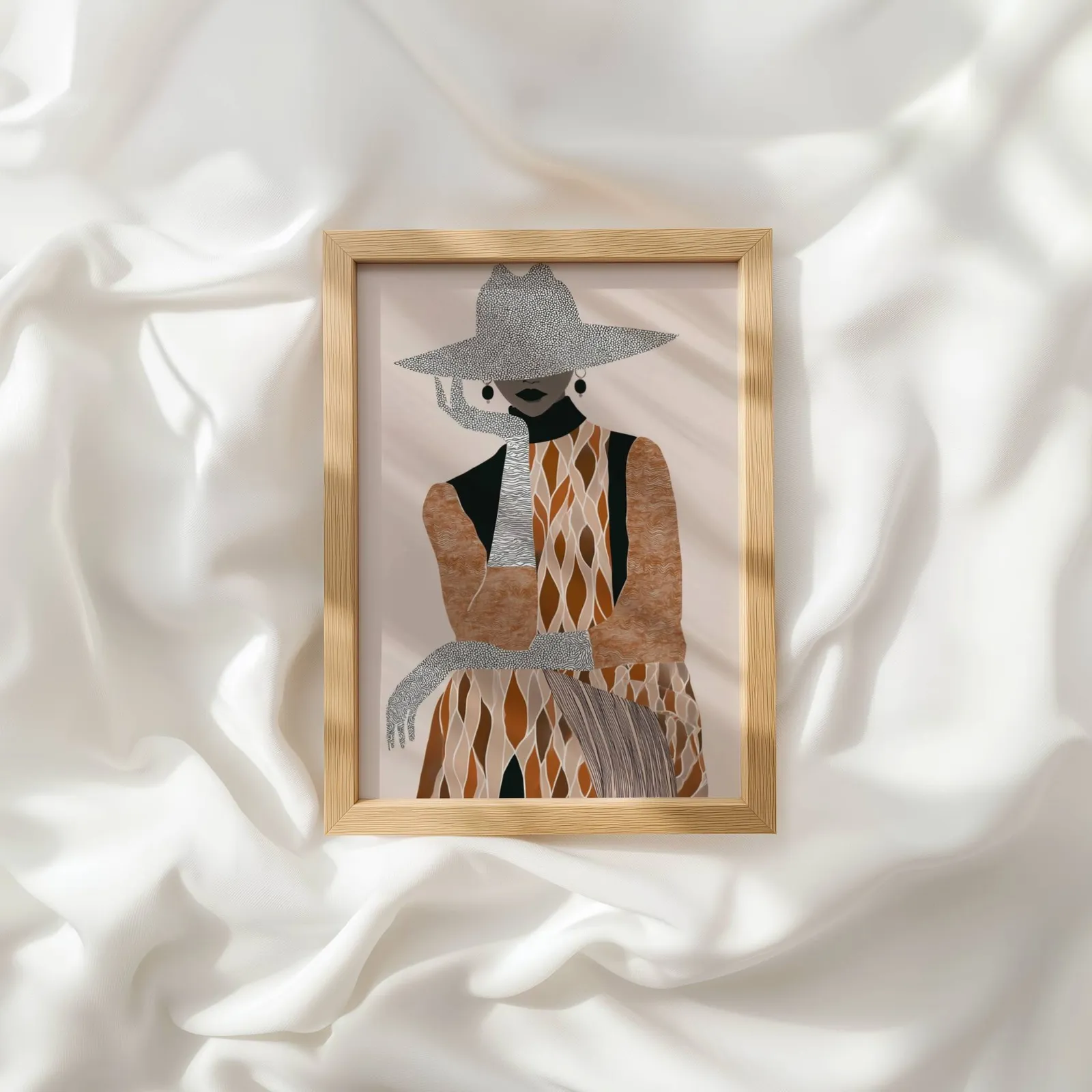 boho woman portrait wall art in brown and cream, resting atop rumpled white silky fabric