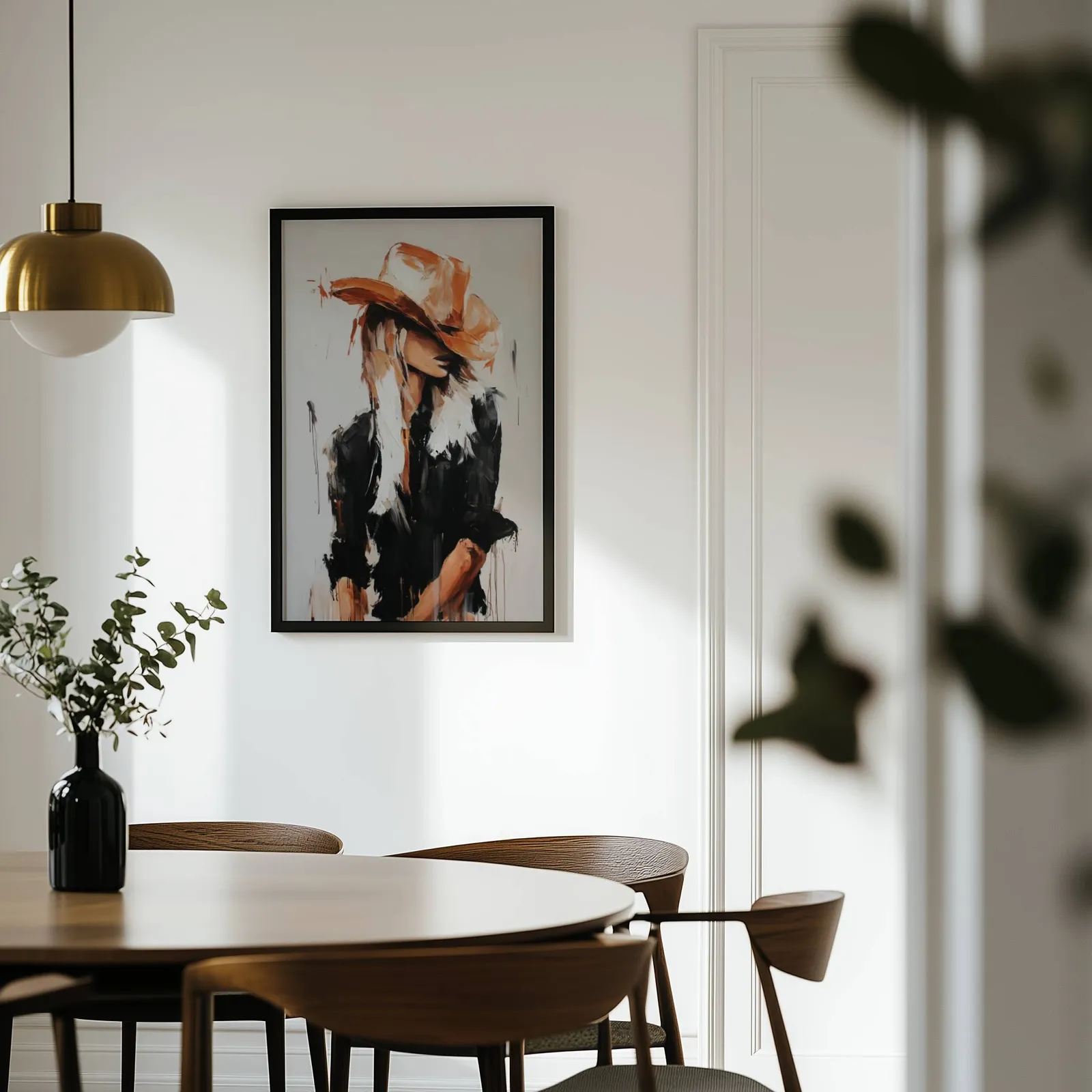 western cowgirl abstract wall art in black and terracotta, on a white wall above a round wooden dining table