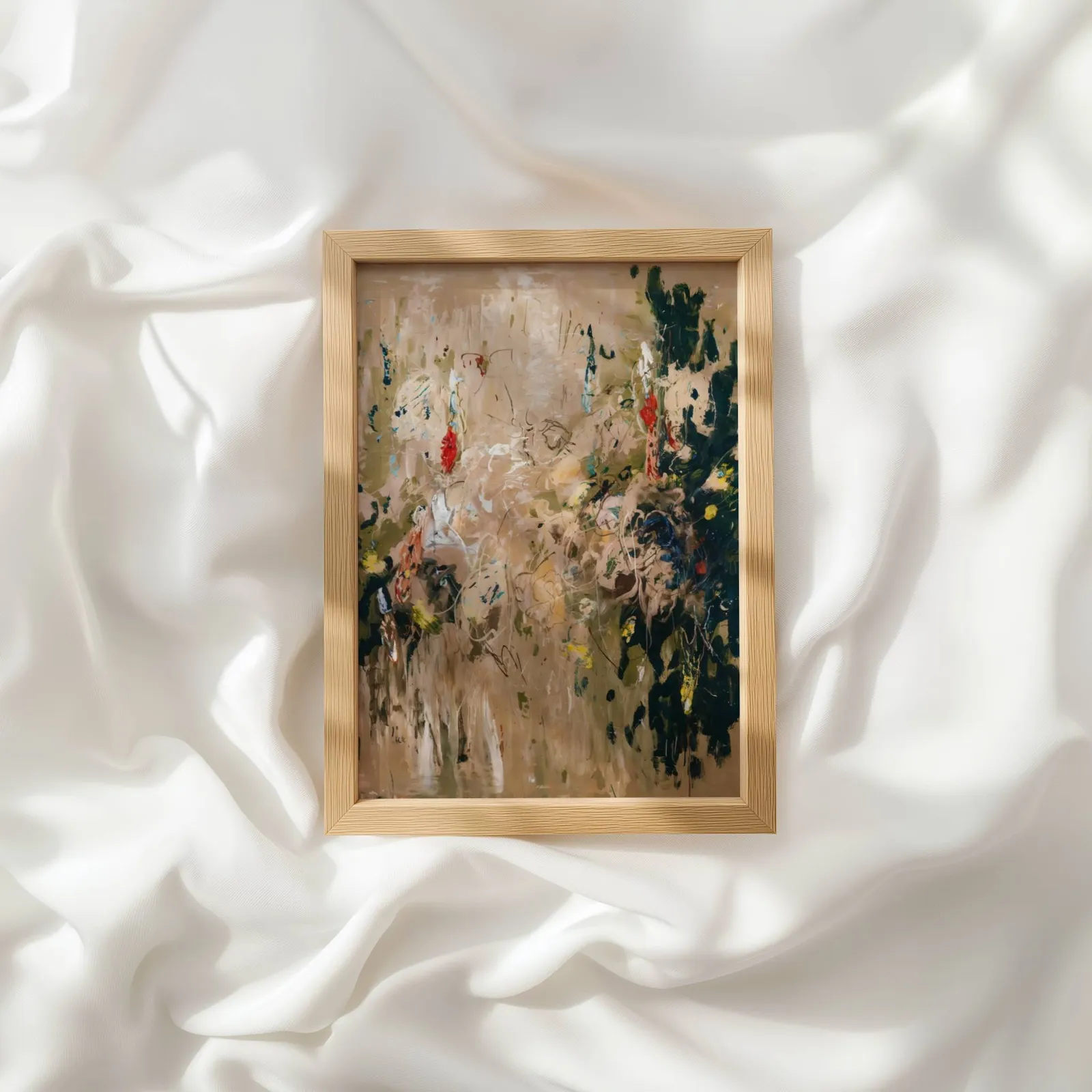 abstract floral wall art in beige and green, resting atop rumpled white silky fabric