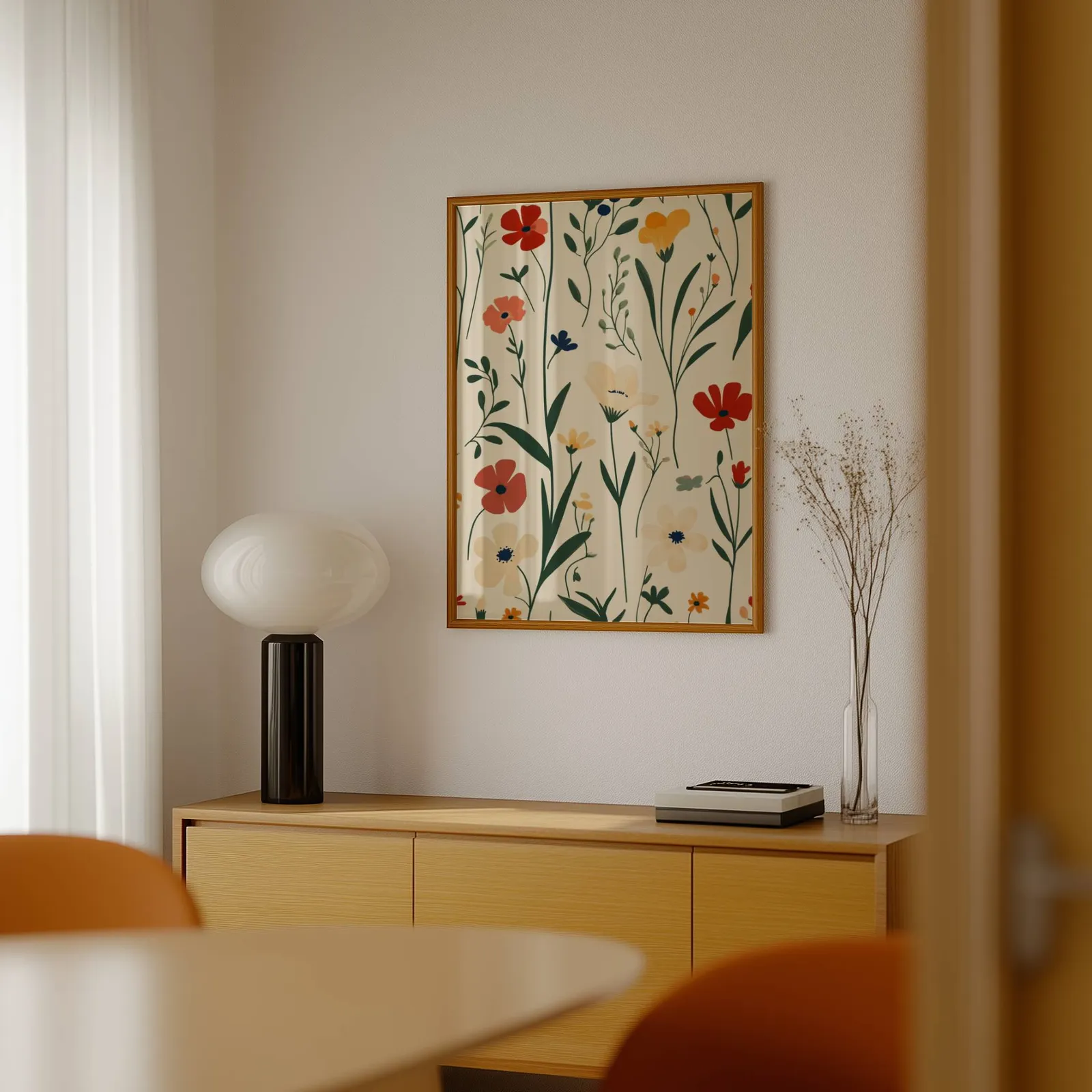 colorful wildflower botanical wall art, above a light wood sideboard beside a bulbous black lamp