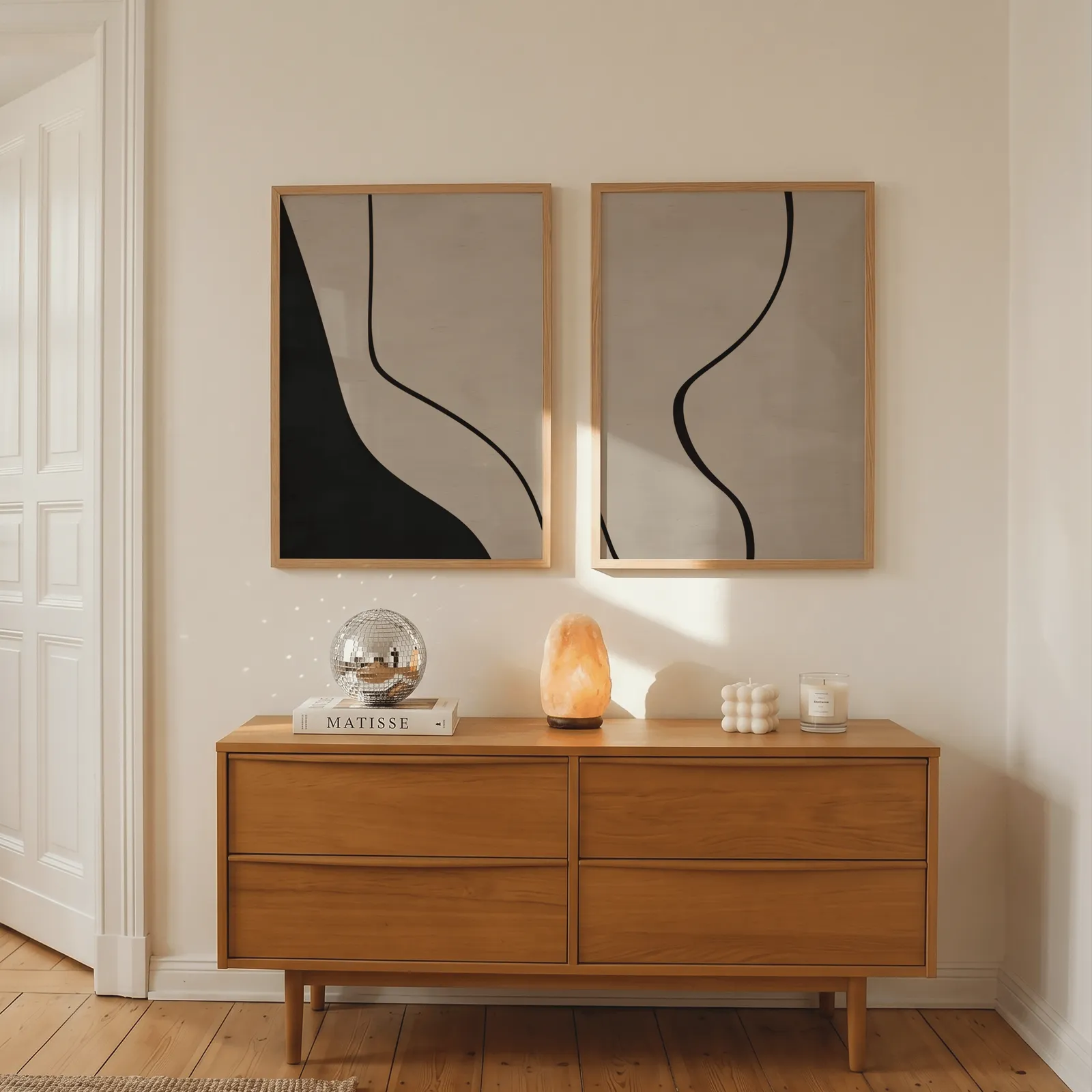 beige abstract minimalist wall art set of two, above a wooden dresser with a salt lamp and disco ball