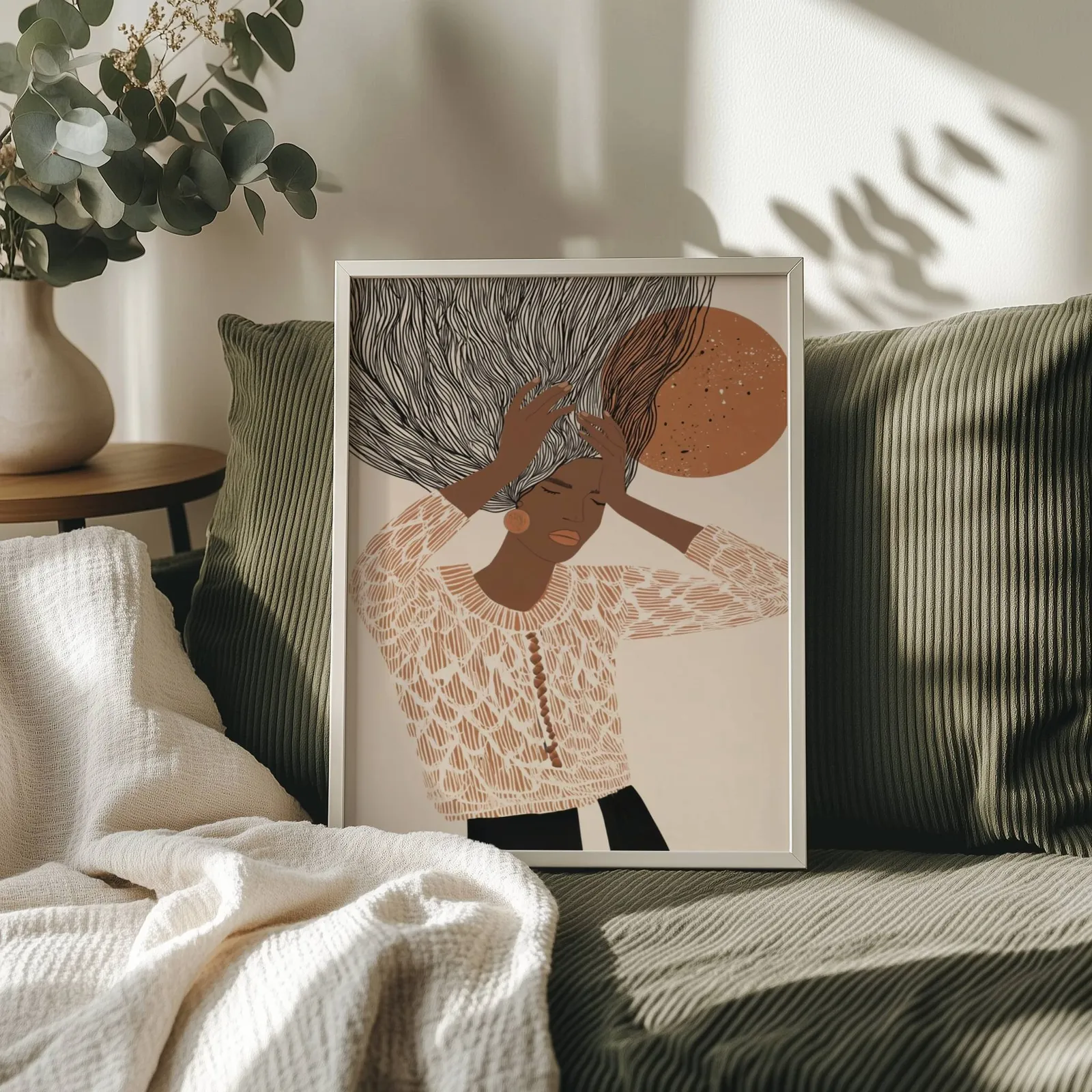 terracotta abstract woman wall art with flowing hair, propped on an olive corduroy sofa beside a eucalyptus vase